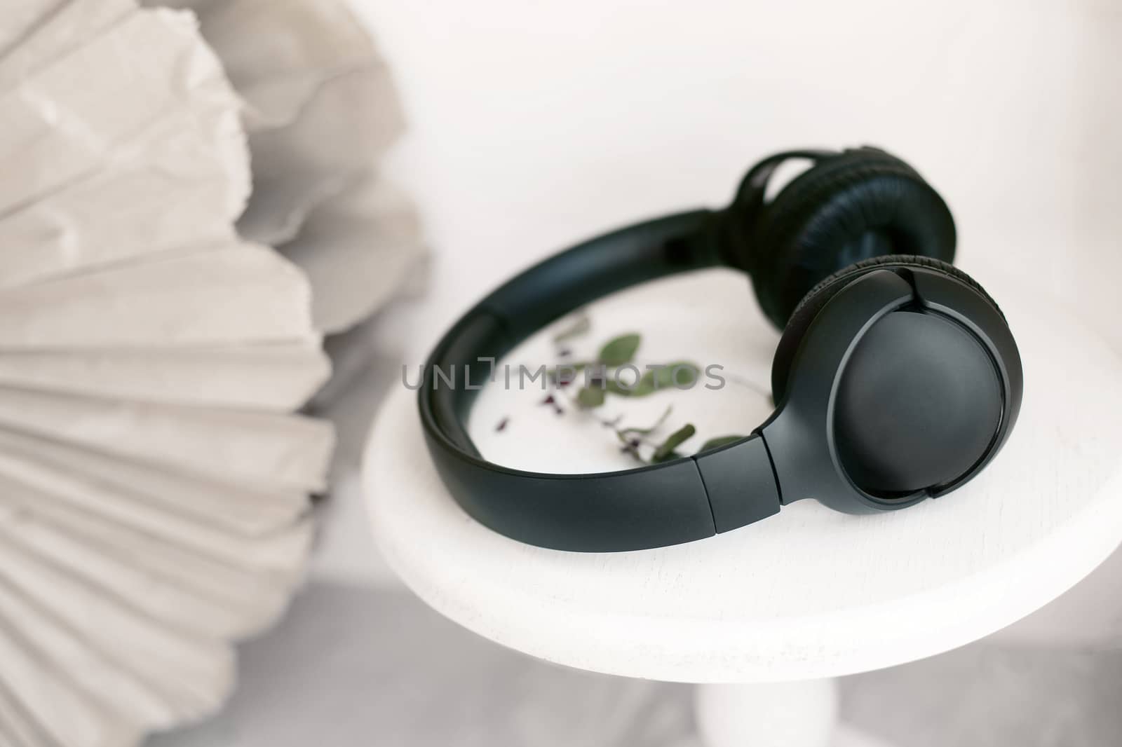 Black headphones on a white stand by Denys_N