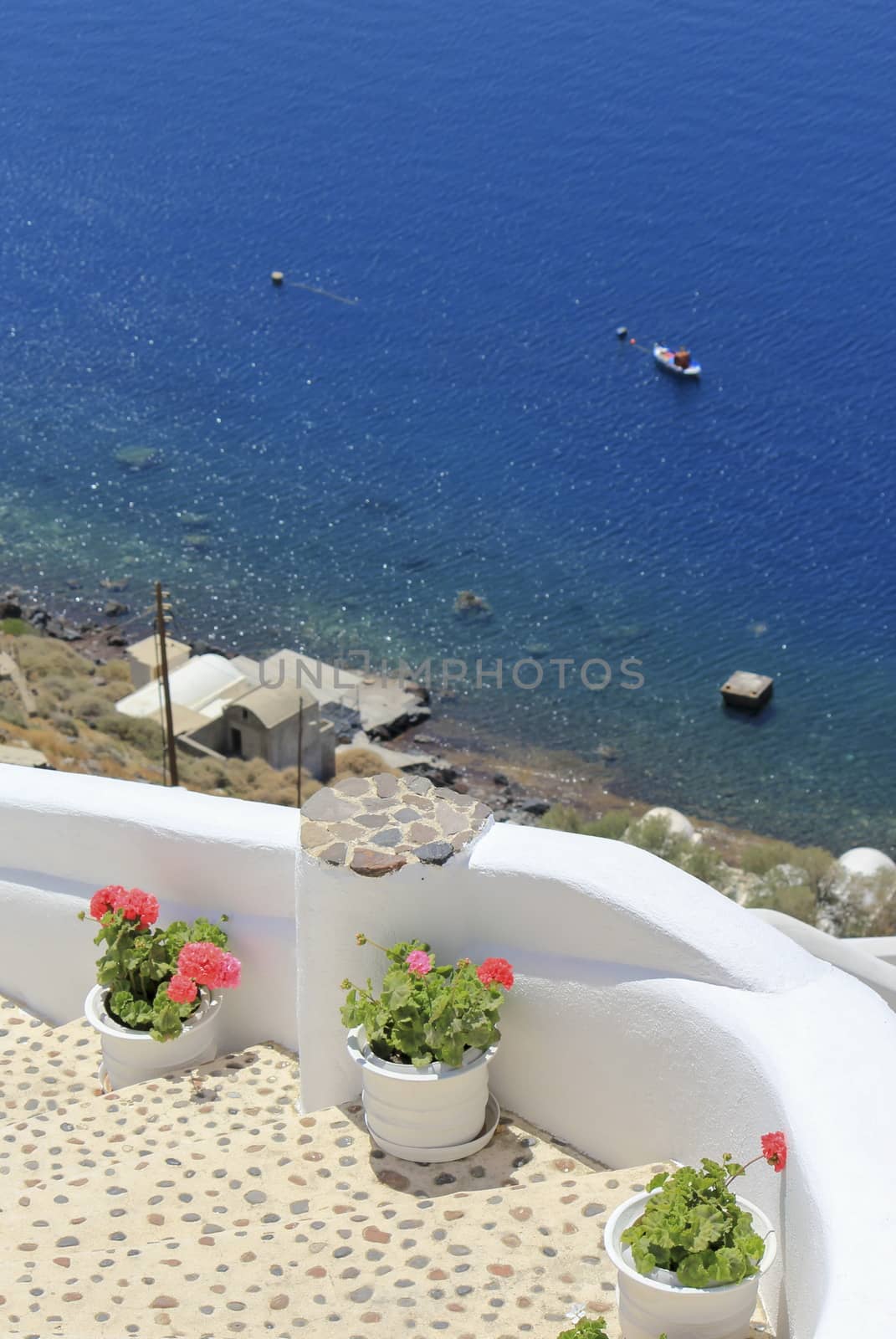 Stairs, flowers and sea at Oia island by beautiful day, Greece