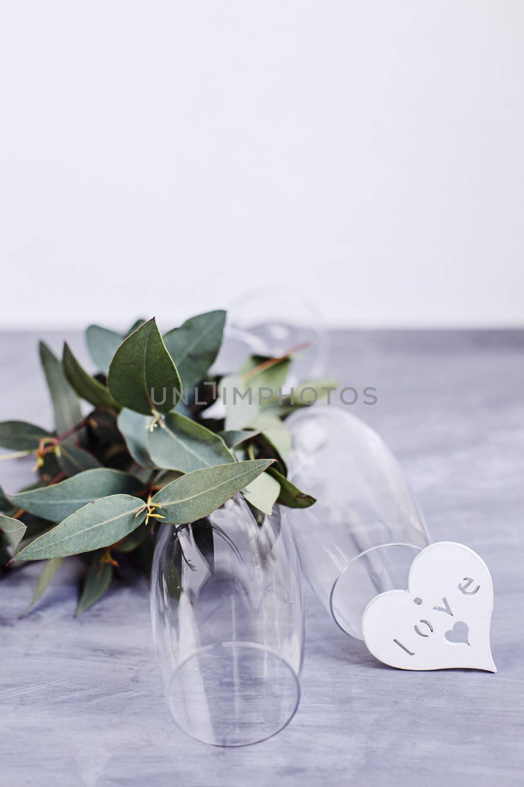 Composition with glass for champagne. Flowers and hearts on grey concrete background. by Denys_N