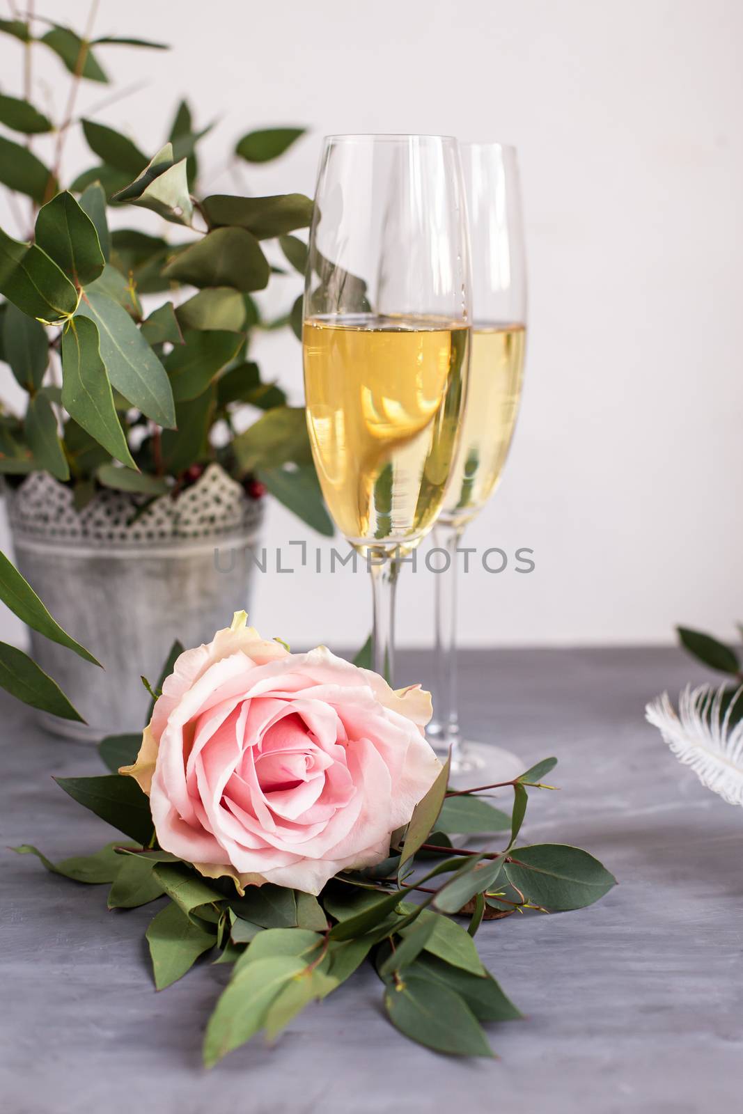 Composition with glasses of vine and flowers on grey concrete background