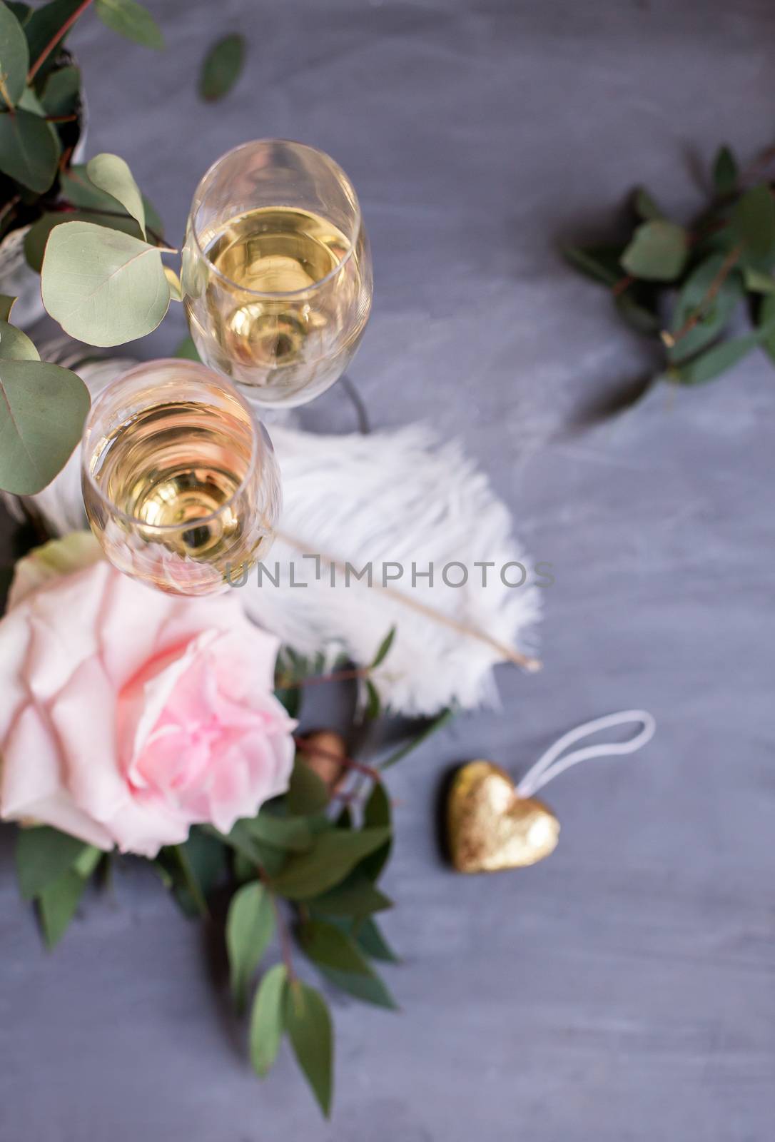 Composition with glasses of vine and flowers on grey concrete background