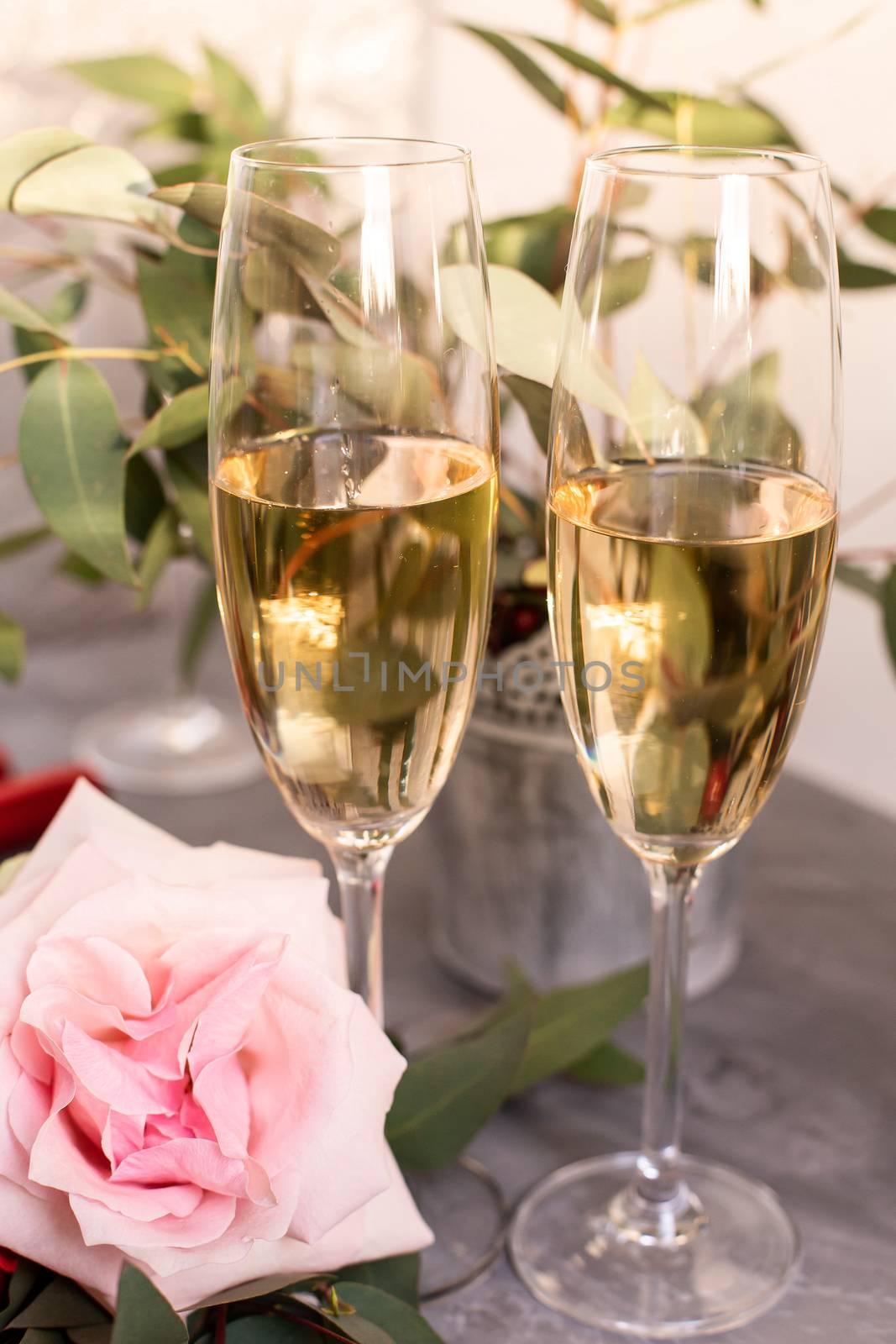 Composition with glasses of vine and flowers on grey concrete background