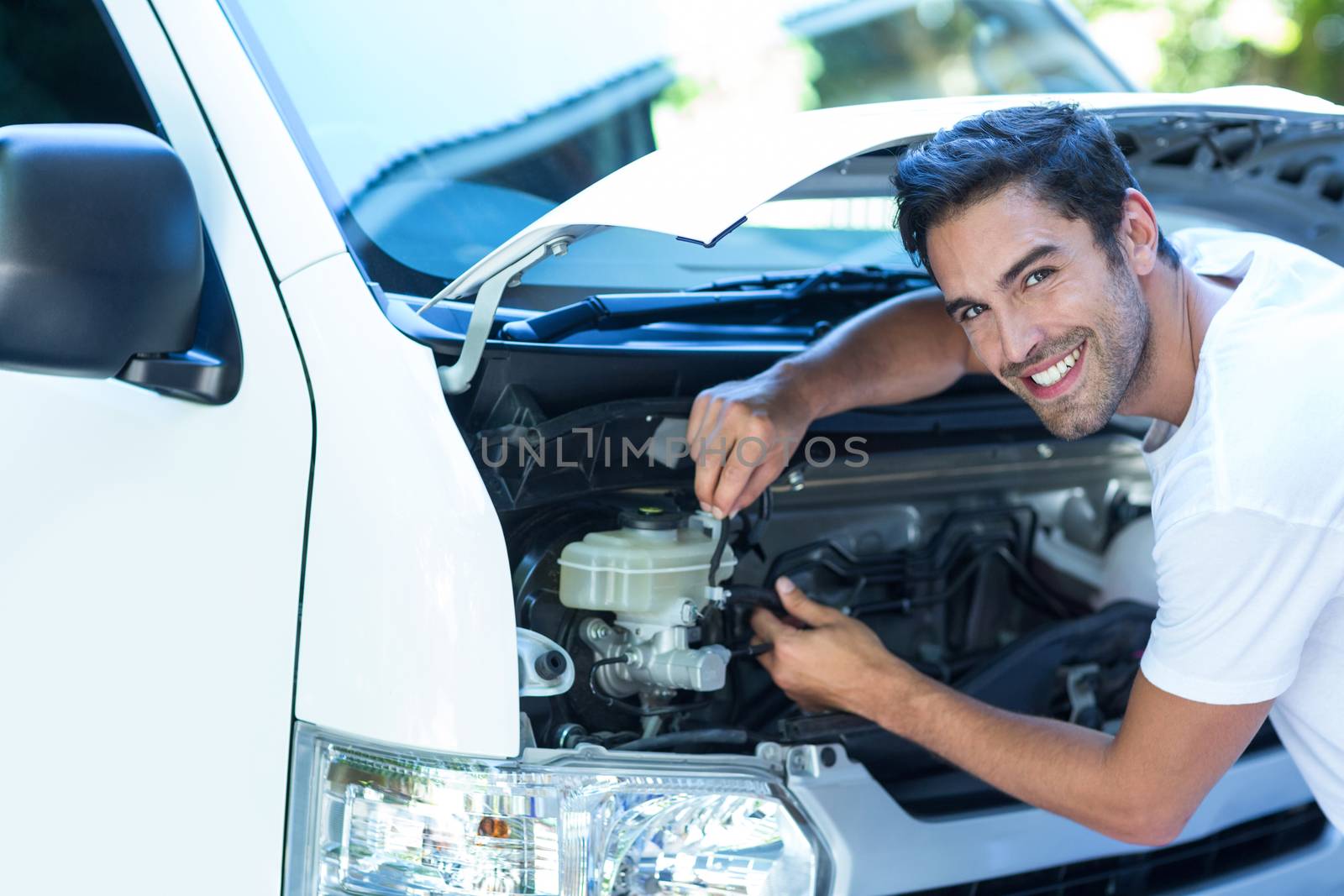 Portrait of happy mechanic fixing van outdoors
