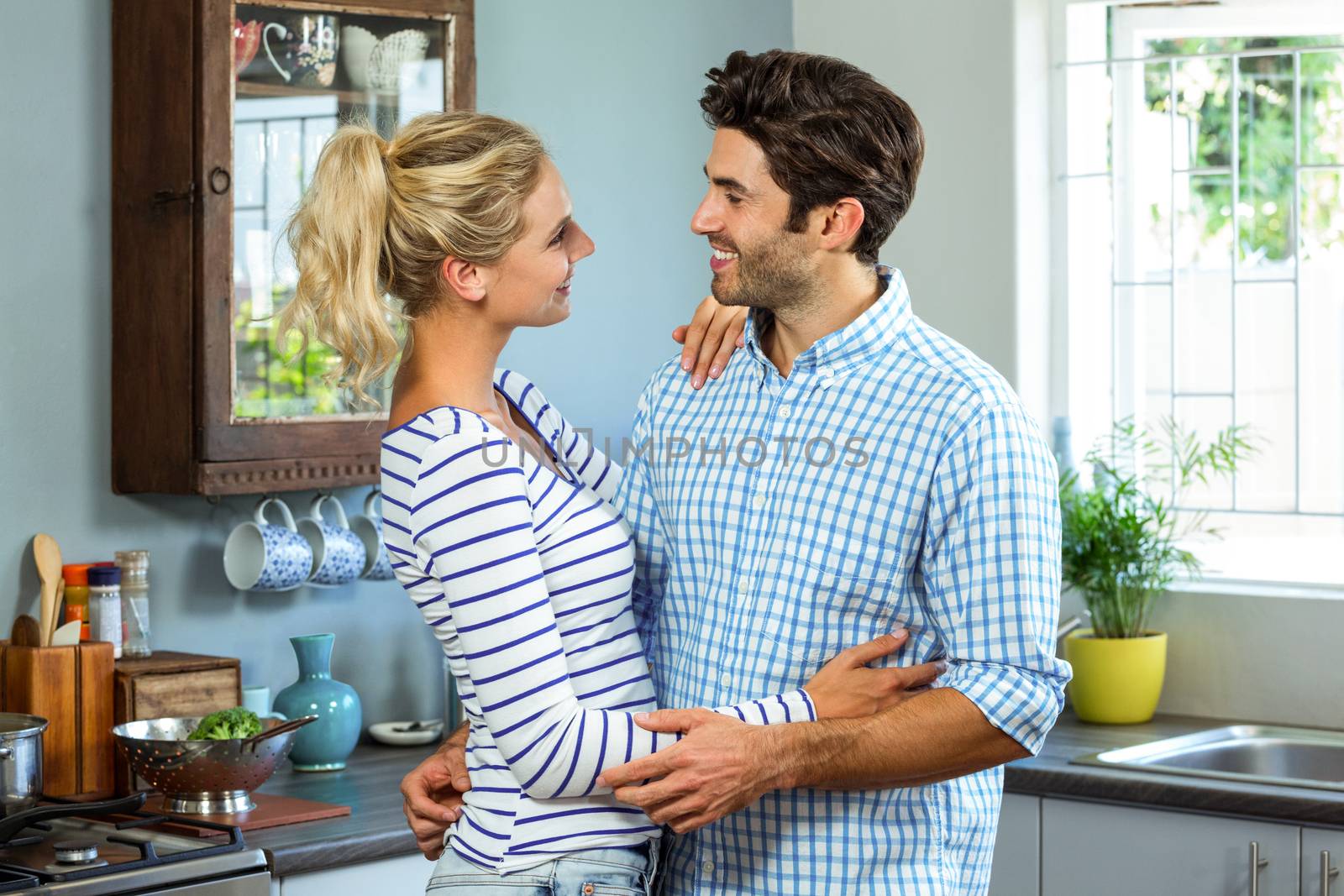 Romantic couple embracing each other in kitchen