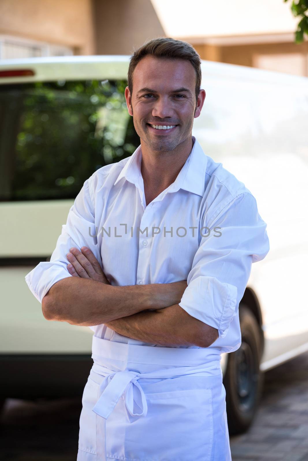 Delivery man standing in front of his van by Wavebreakmedia