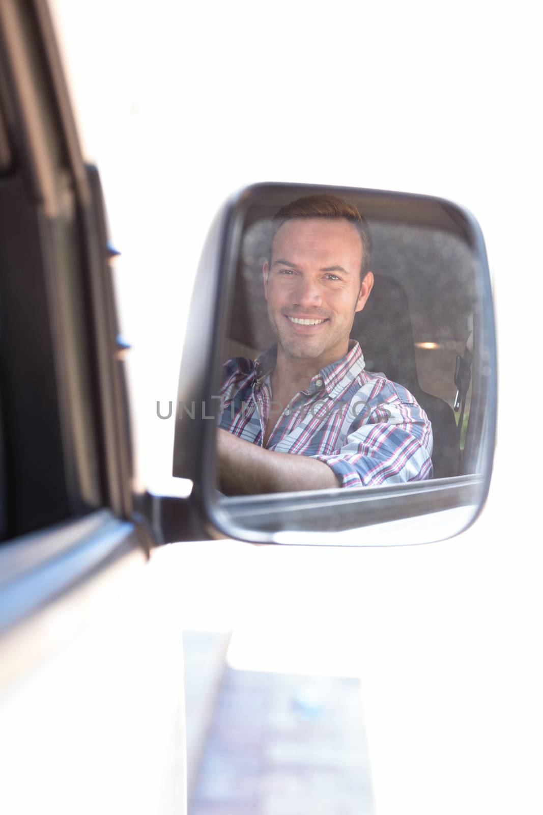 Young man driving with his reflection in rear view mirror by Wavebreakmedia