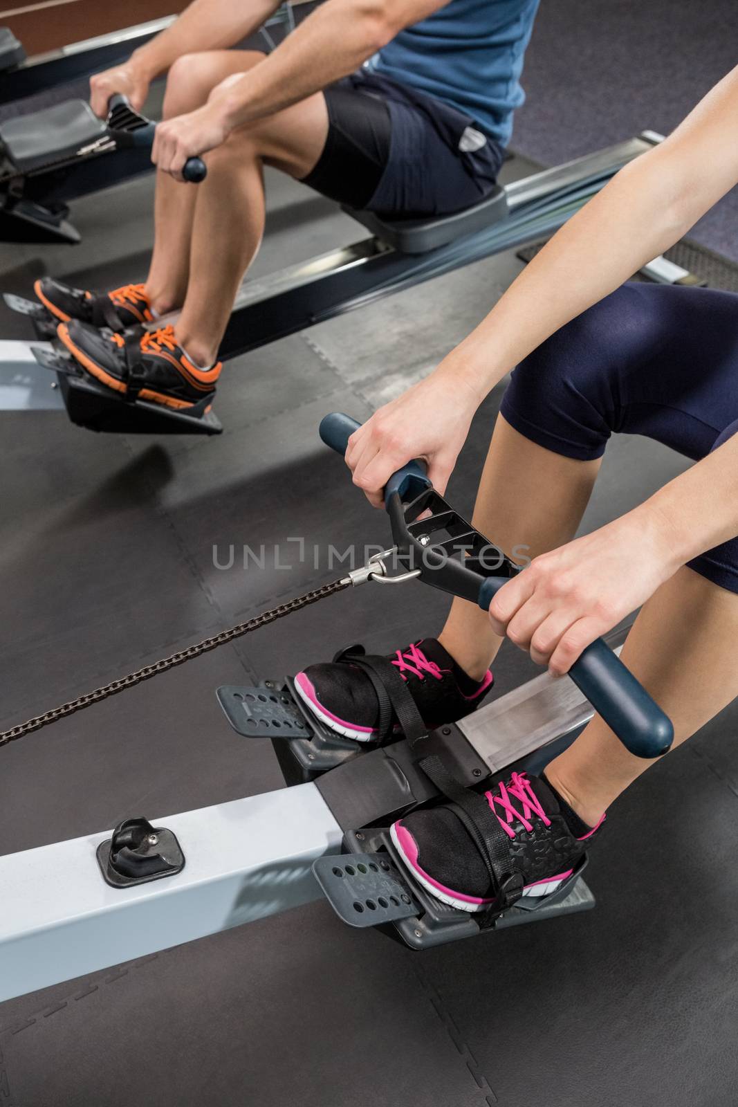 Mid section of people exercising on rowing machine by Wavebreakmedia