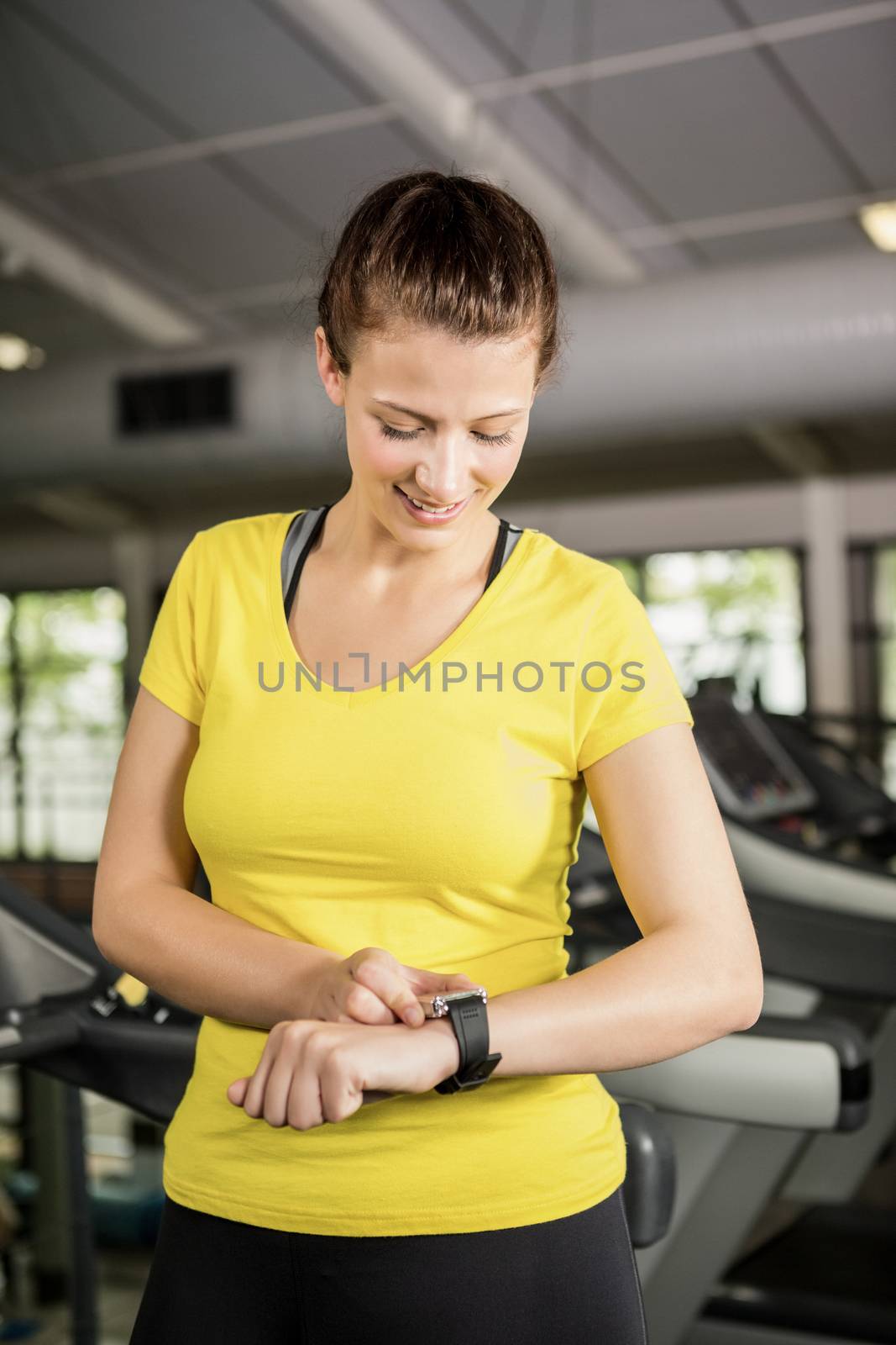 Woman using smart watch on treadmill by Wavebreakmedia