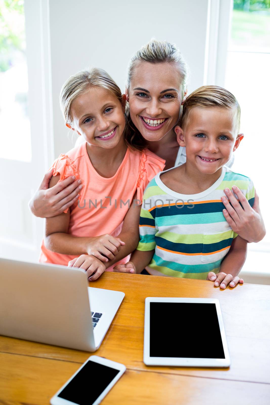 Happy mother with children by technology at home  by Wavebreakmedia