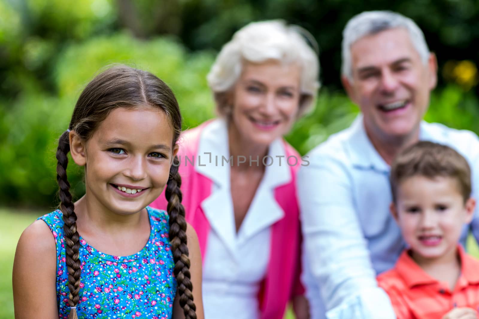 Girl with brother and grandparents at yard  by Wavebreakmedia