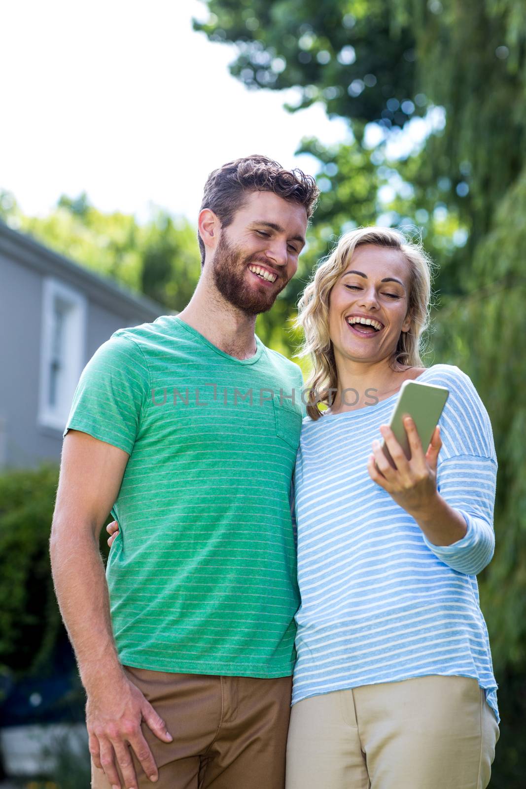 Happy couple taking selfie in yard