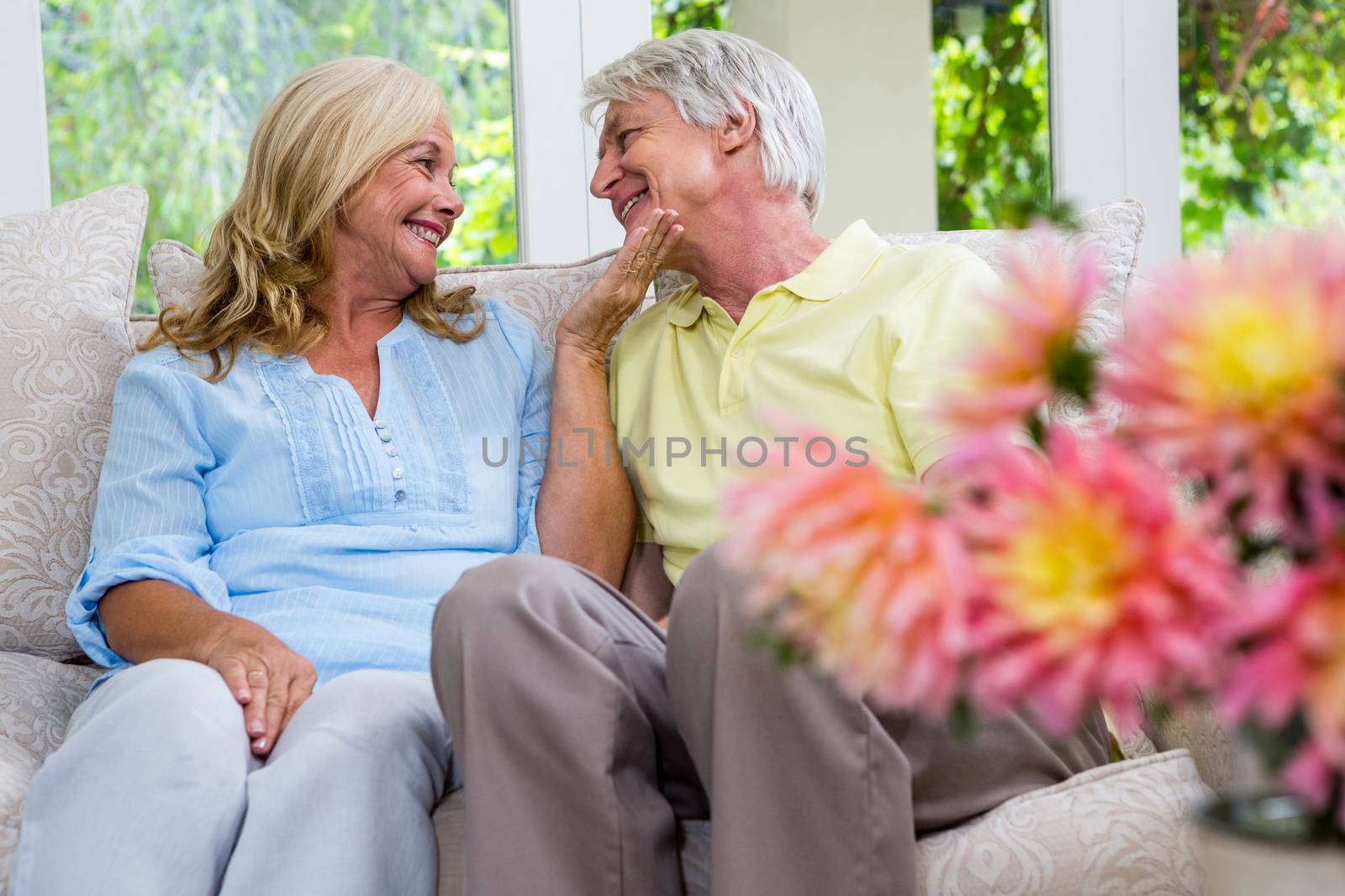 Romantic senior couple sitting in living room at home