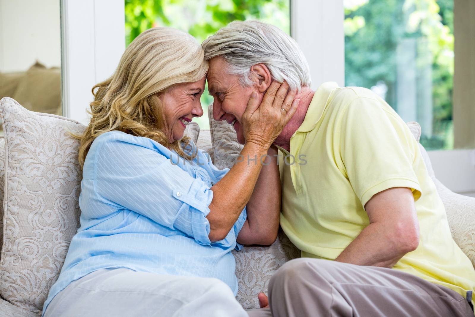 Romantic senior couple emracing in living room at home