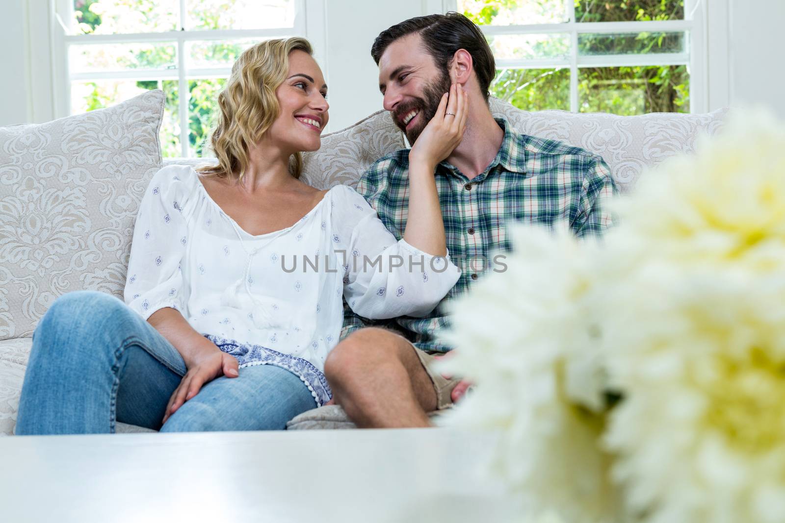Romantic young couple sitting on sofa at home