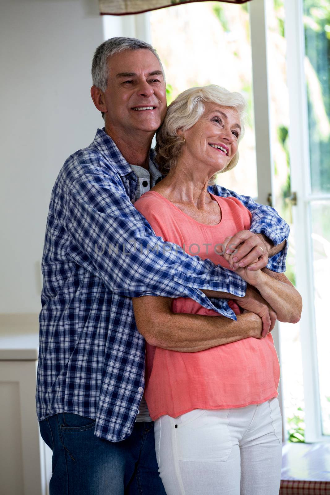 Romantic smiling couple embracing in kitchen at home