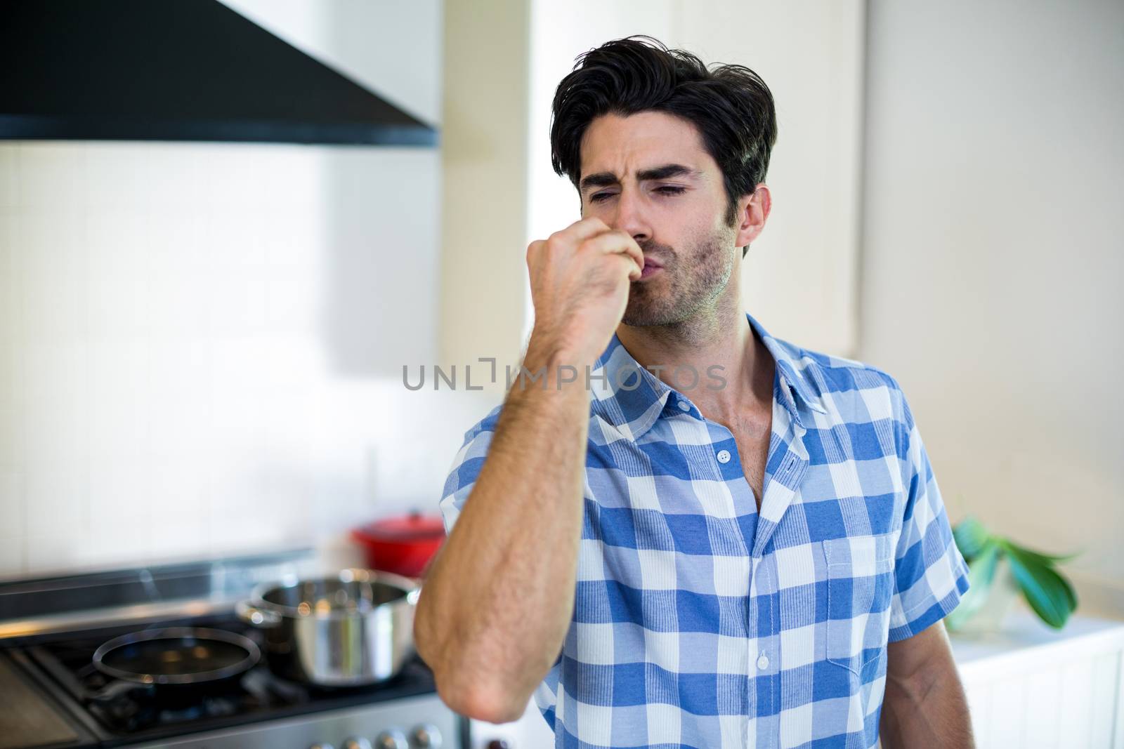Man  giving a flying kiss in kitchen by Wavebreakmedia
