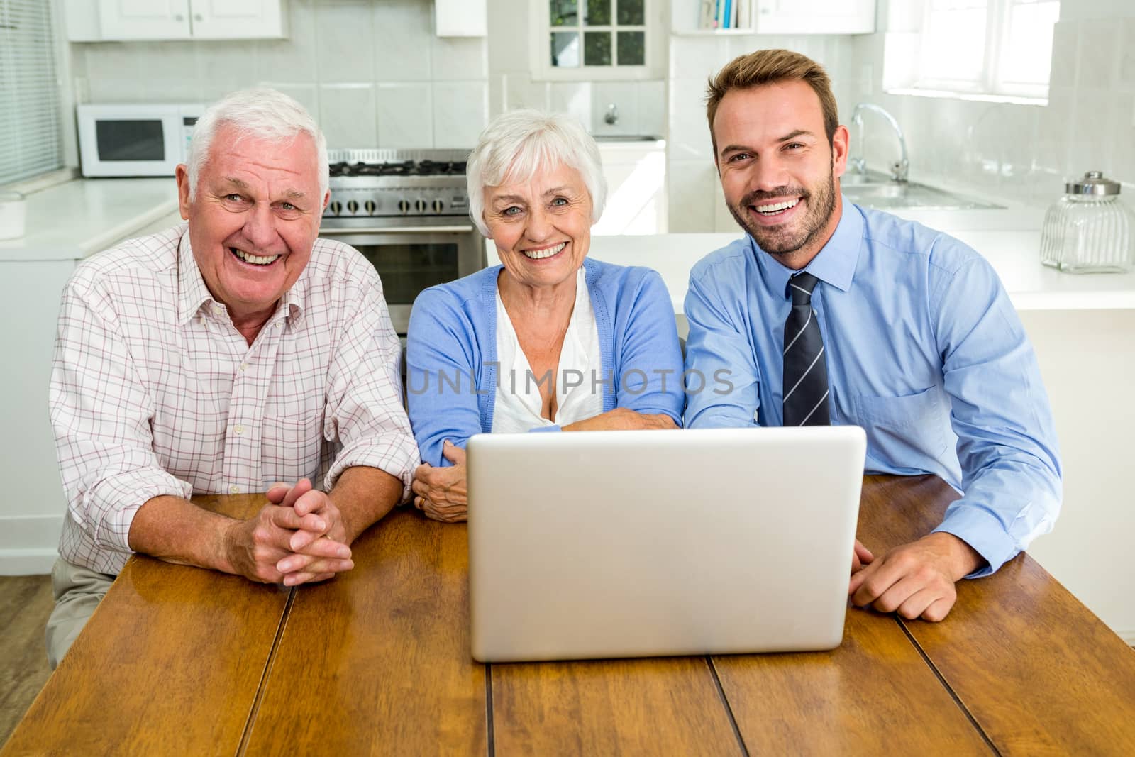 Portrait smiling senior couple sitting with agent at home