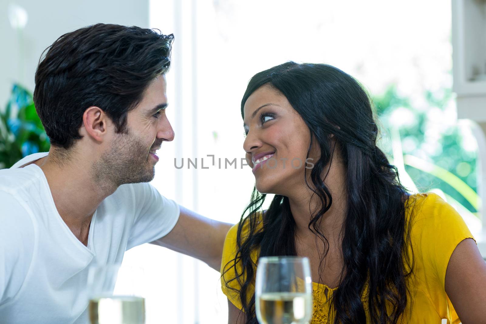 Romantic couple looking at each other and smiling at home