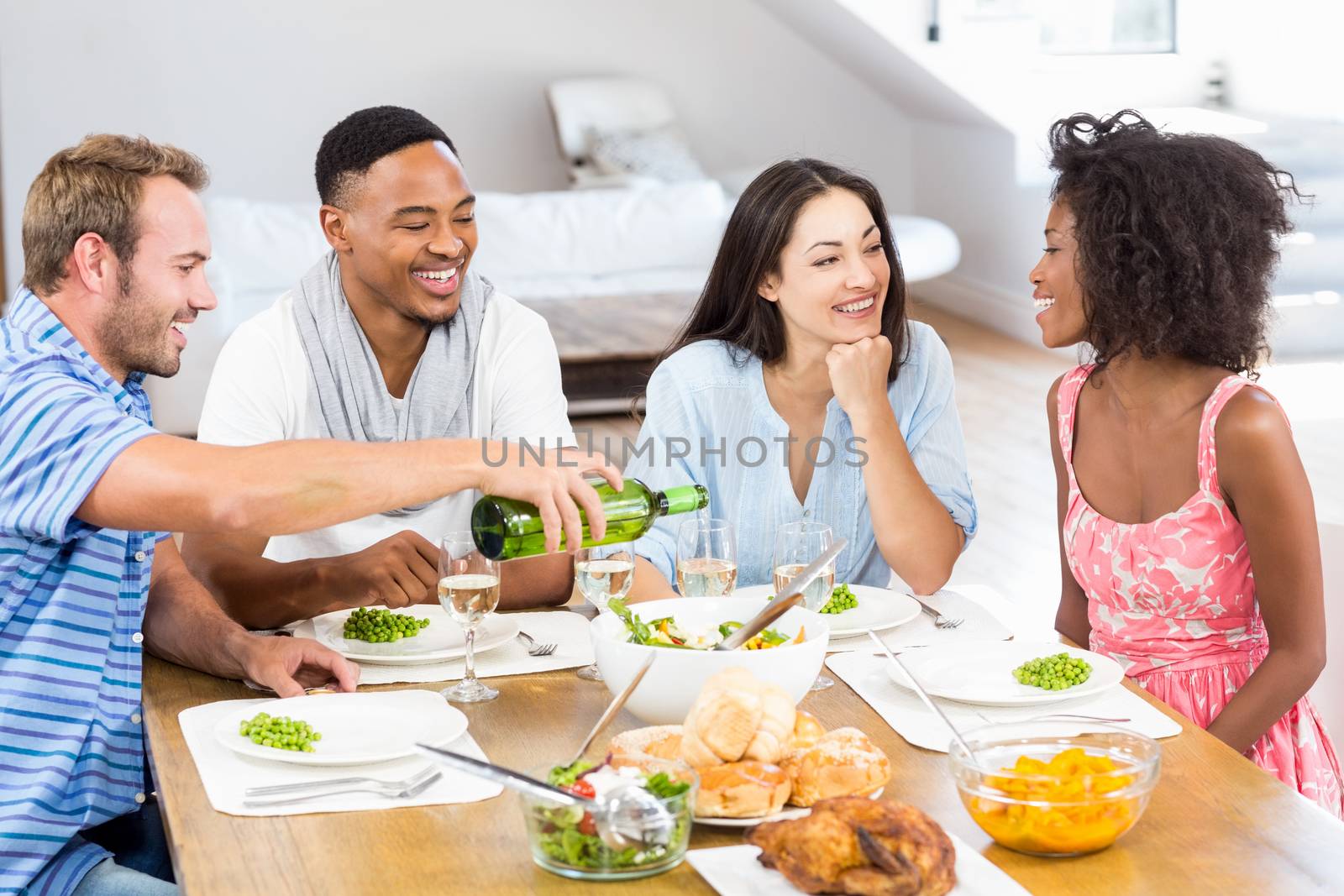 Friends interacting while having a meal at dining table