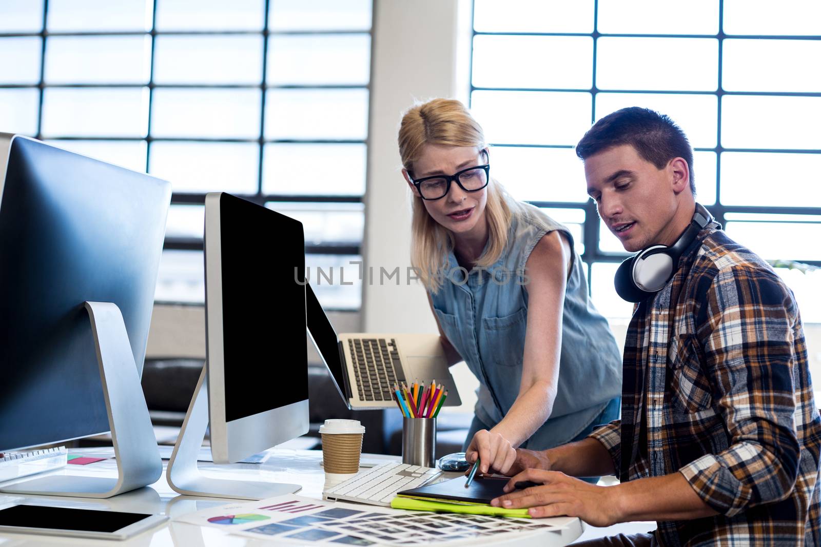 Graphic designer interacting at their desk by Wavebreakmedia