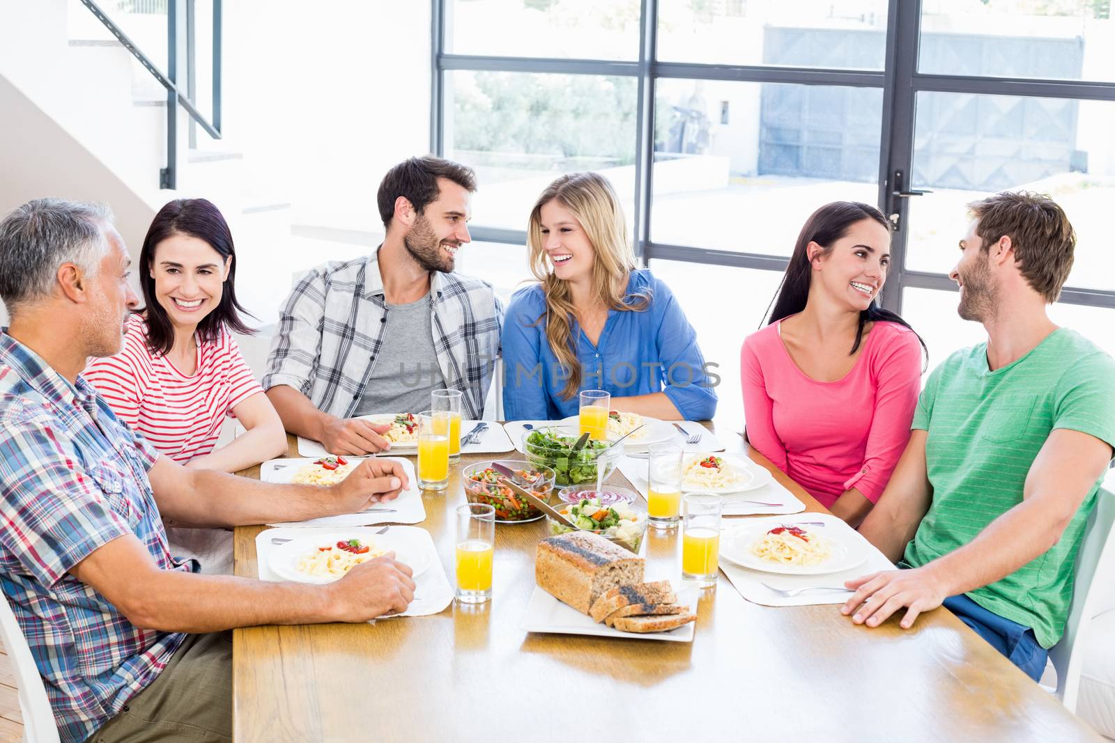 Friends interacting while having a meal at dining table