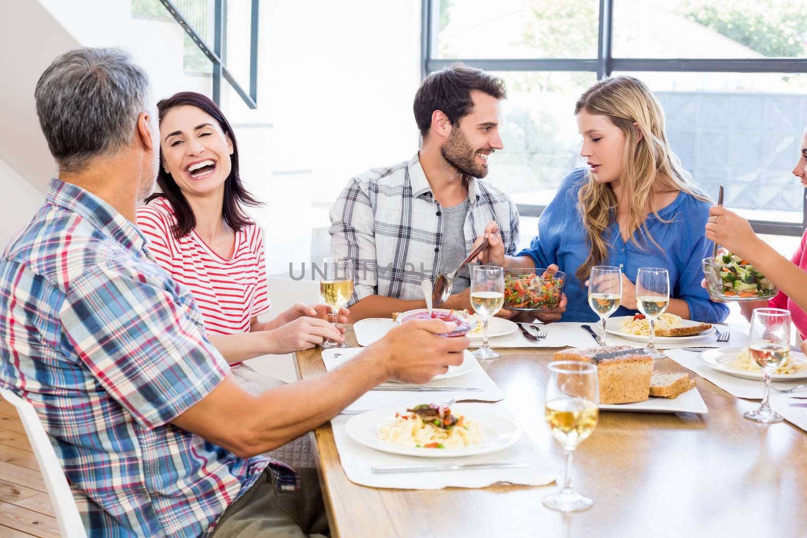 Friends interacting while having a meal at dining table