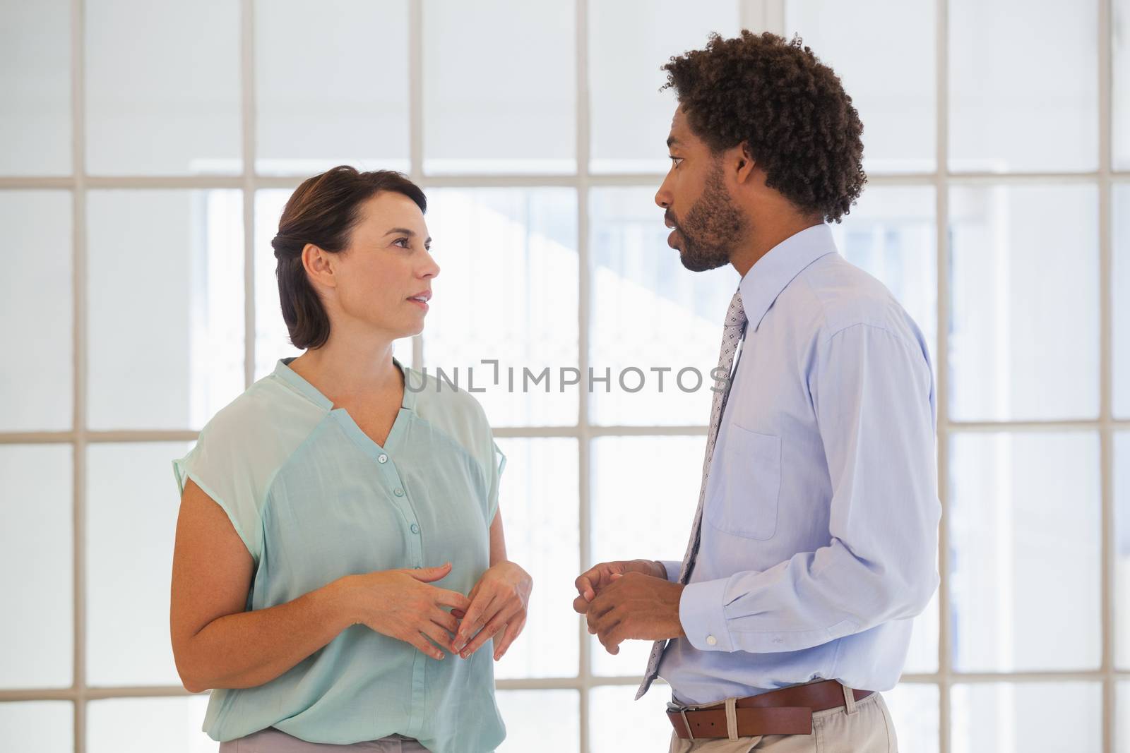 Two young business people having a conversation in the office