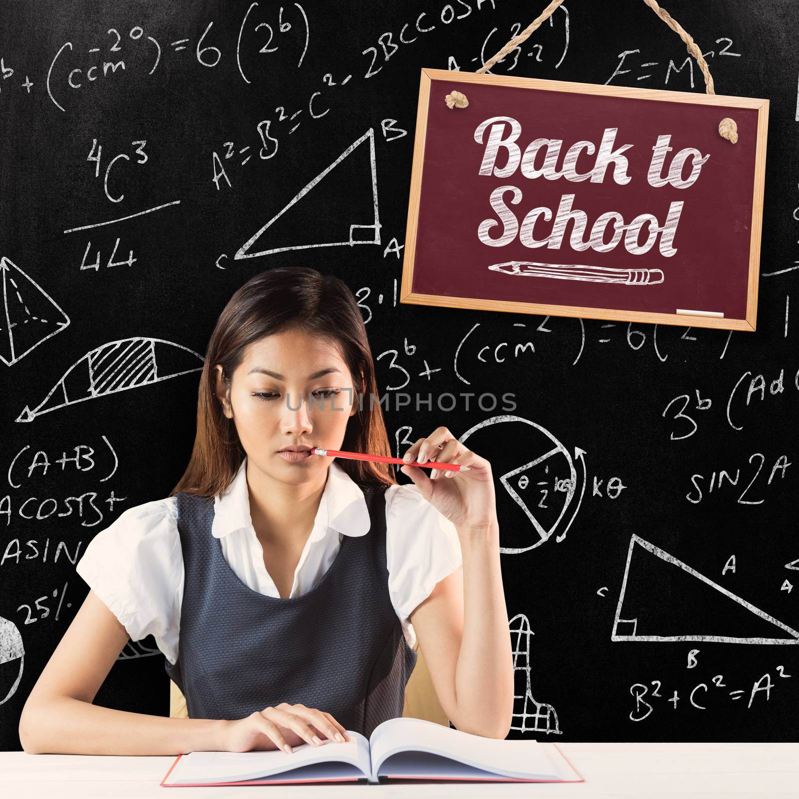 Thoughtful businesswoman reading against blackboard