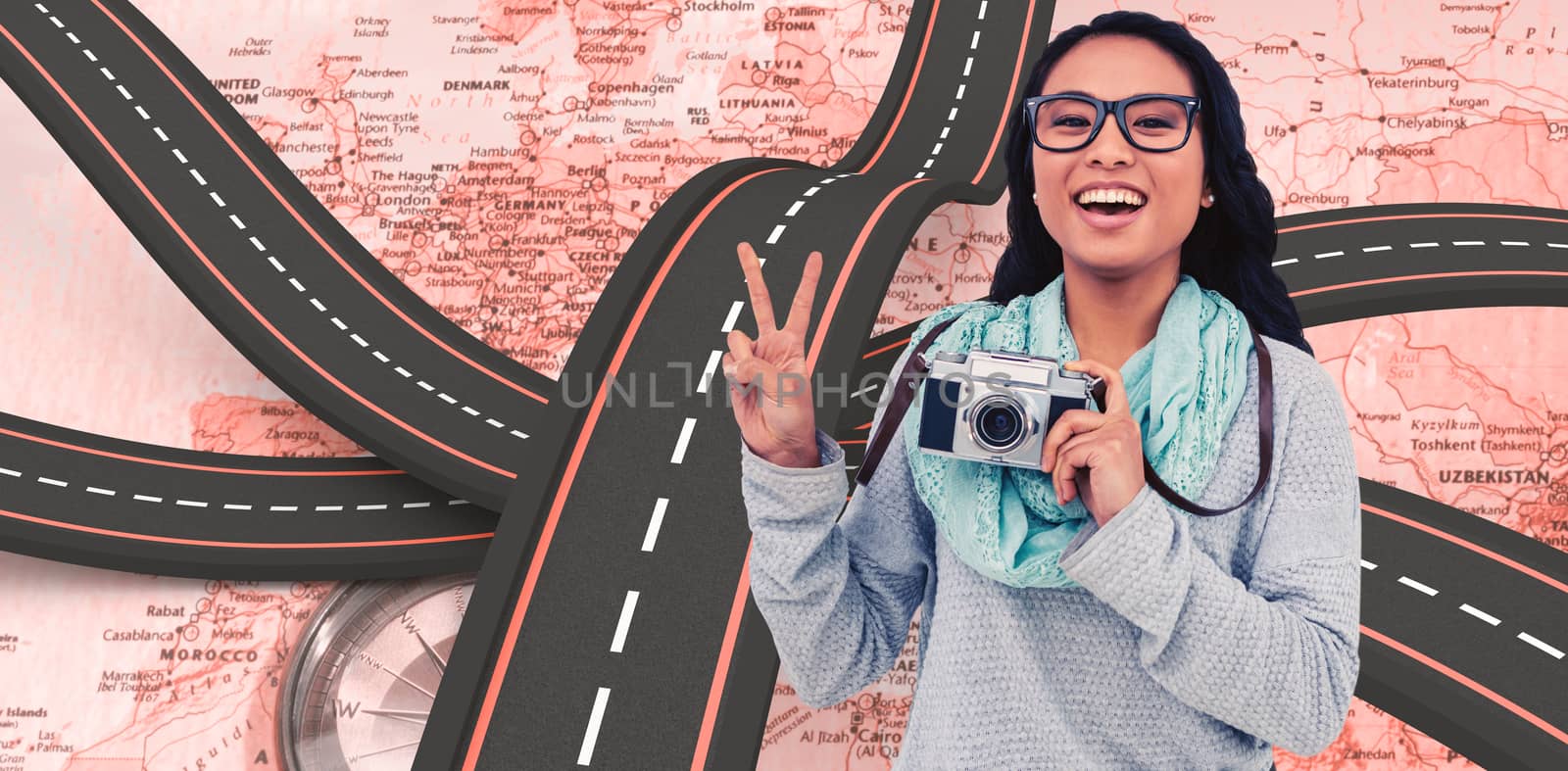 Asian woman holding digital camera and making peace sign with hand against world map with compass showing europe and the middle east