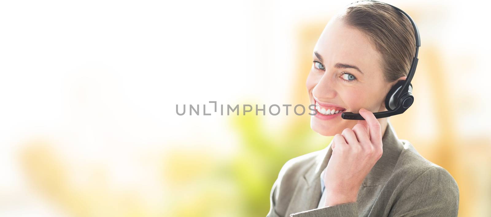 Composite image of smiling businesswoman with headset using computers by Wavebreakmedia