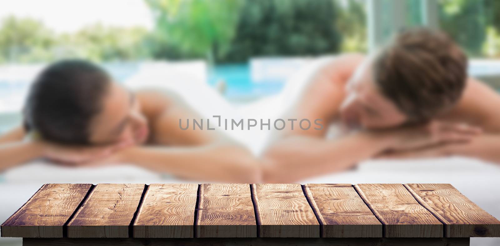 Composite image of couple lying on massage table at spa center by Wavebreakmedia