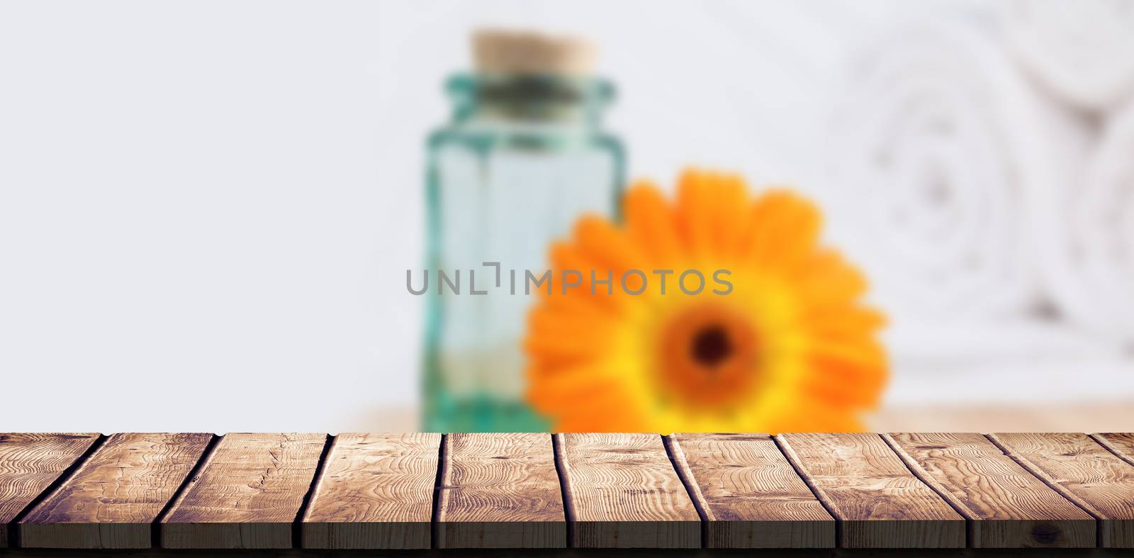 Wooden desk against glass jar and orange flower in spa