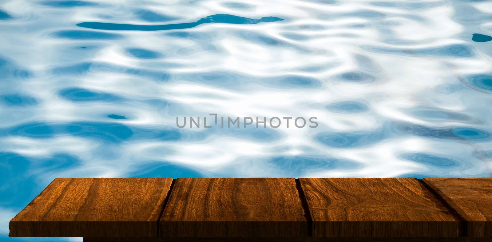 Wooden floor against ripples on blue swimming pool