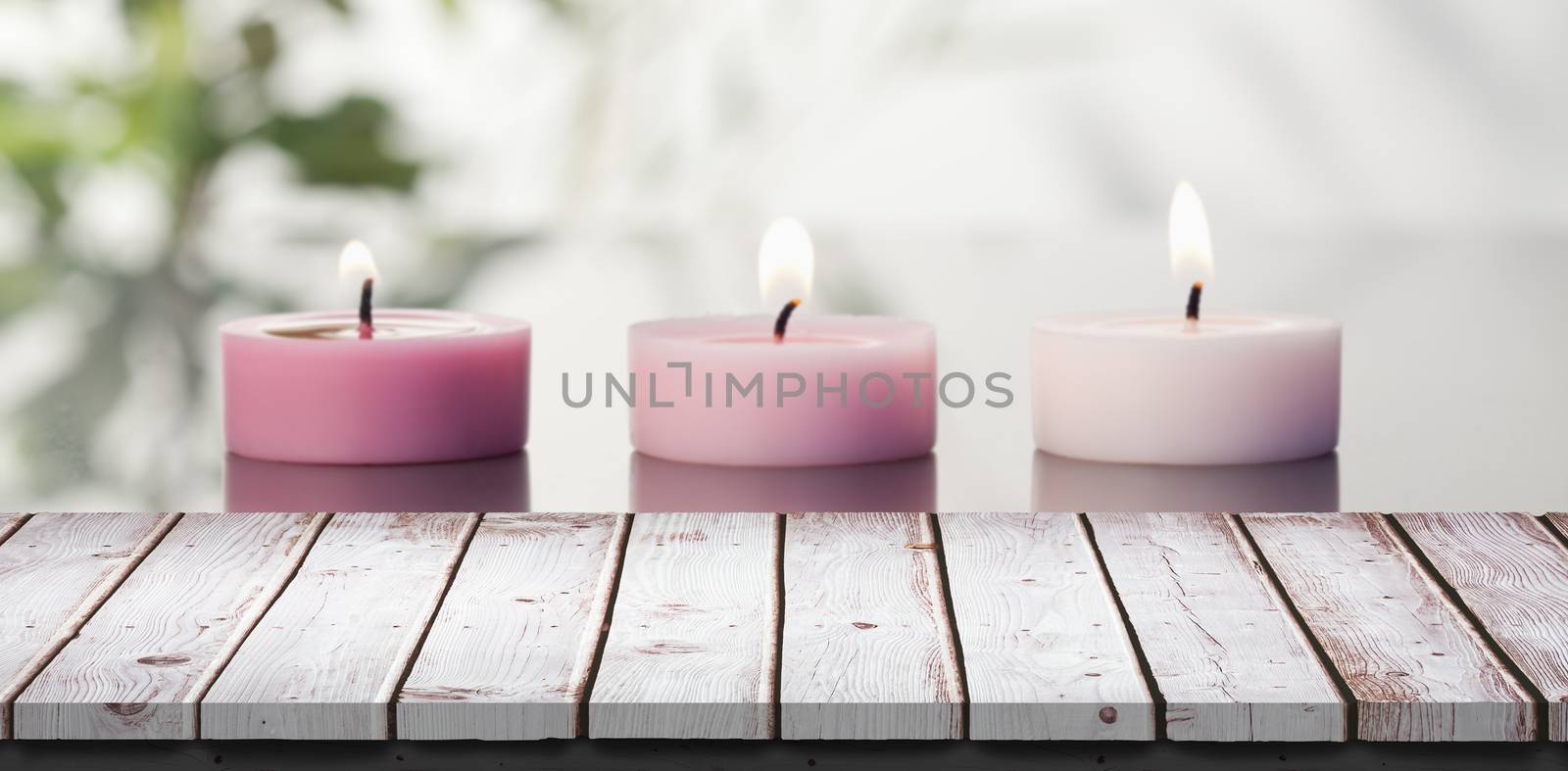 Wooden table against lighted candles on a mirror