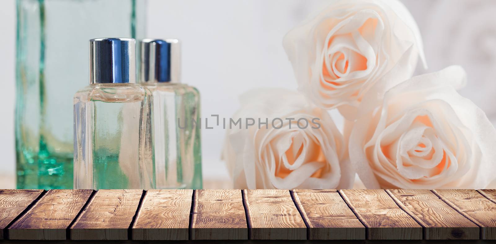 Wooden desk against glass jars and rose flowers in spa
