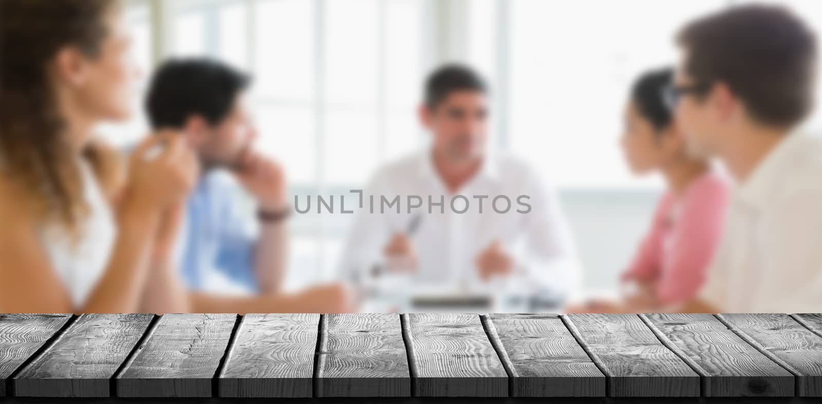 Wooden desk against business people discussing in conference meeting 