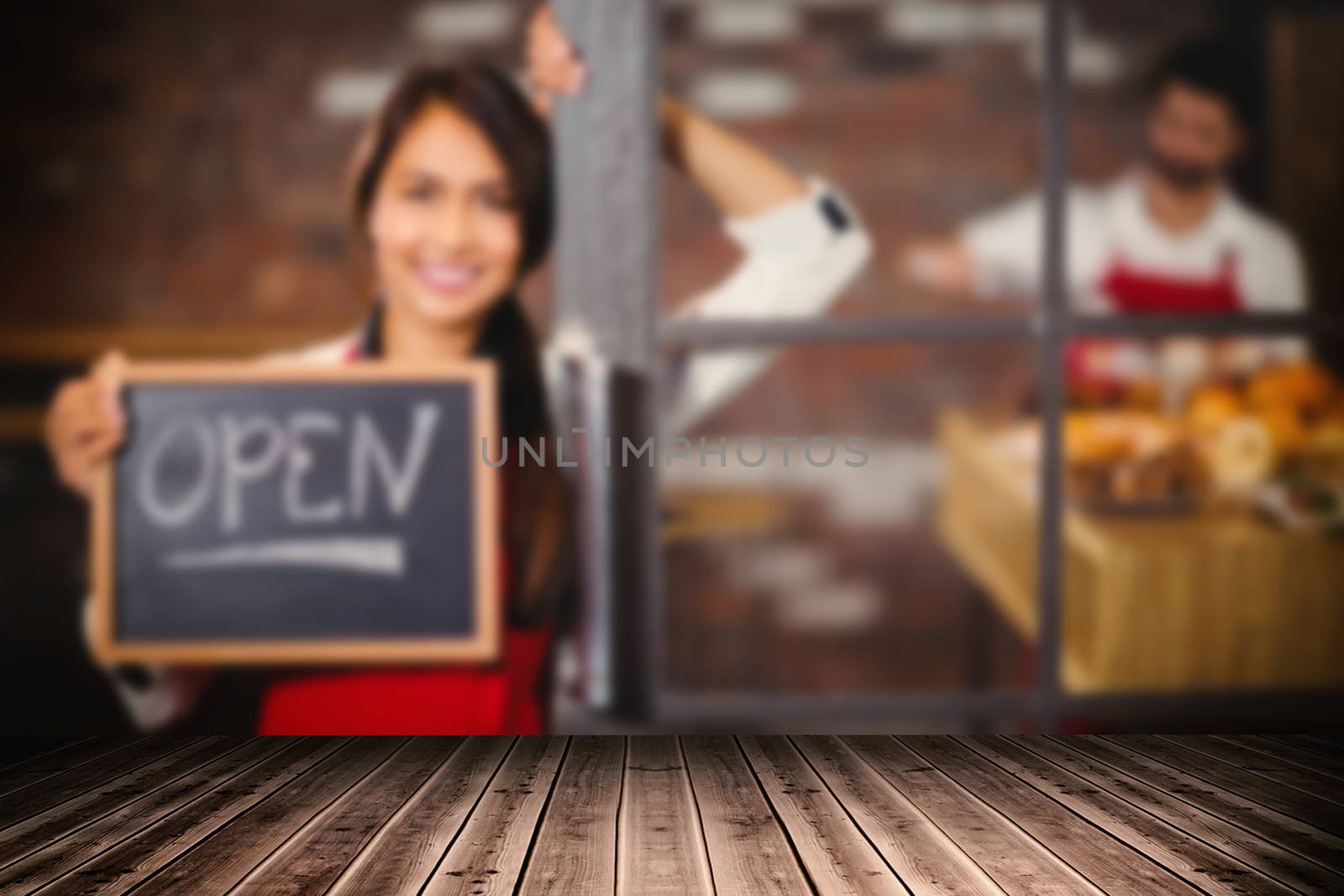 Close-up of wooden flooring against smiling waitress showing chalkboard with open sign 