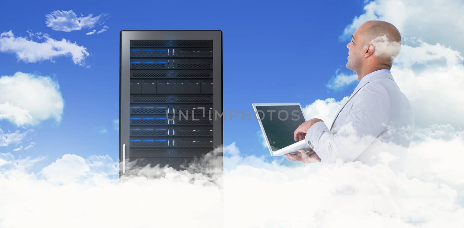 Businessman using laptop against scenic view of blue sky