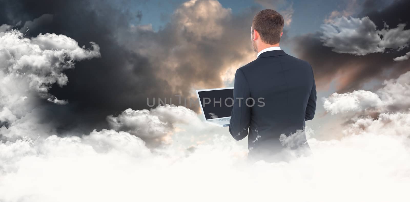 Composite image of businessman looking up holding laptop by Wavebreakmedia