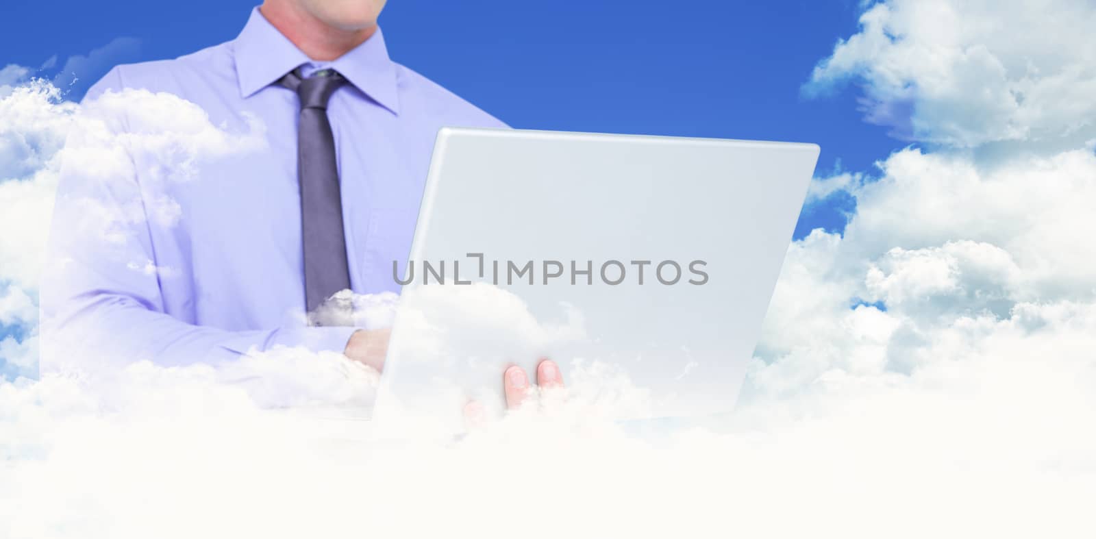 Businessman using a laptop against scenic view of blue sky