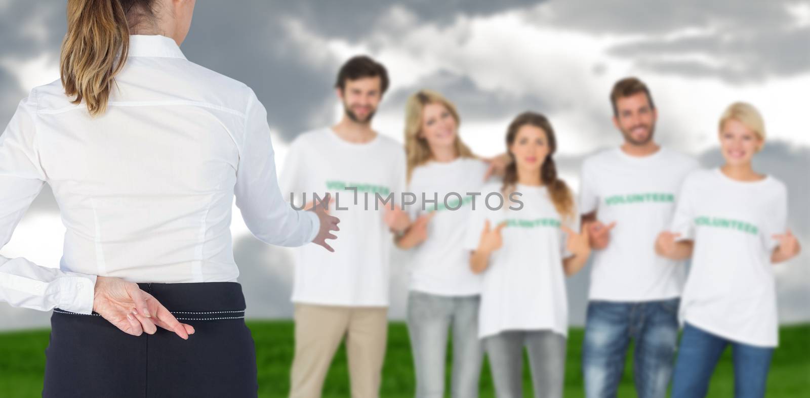 Businesswoman offering handshake with fingers crossed behind her back against grey sky over field