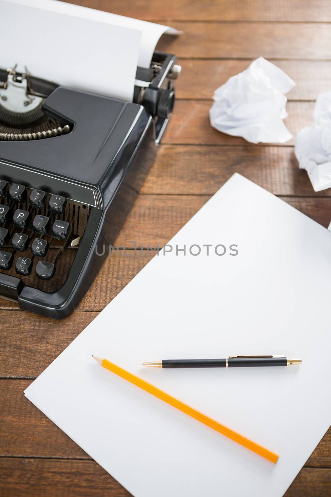 Picture of a type writer with paper and pen