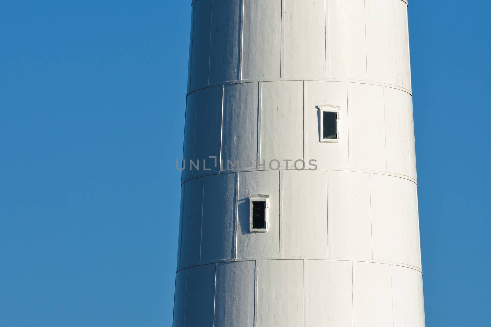 A close-up of the tall white lighthouse tower at slangkop, Cape Town, South Africa