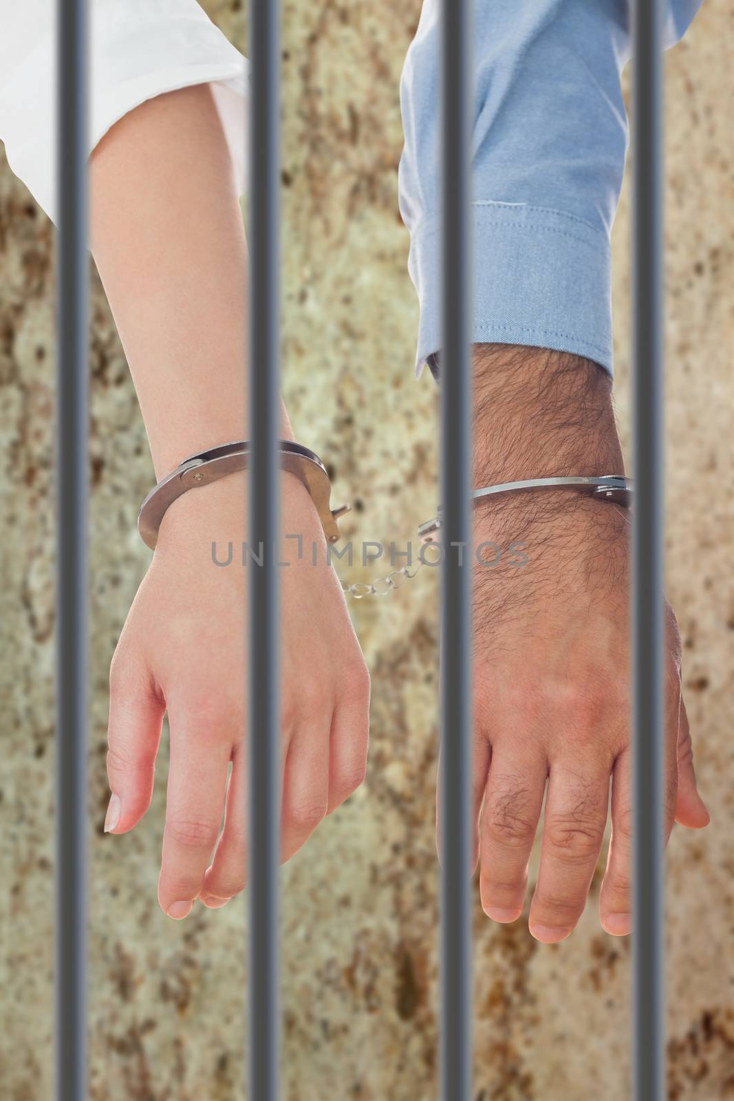 Closeup of handcuffed business people against dirty old wall background