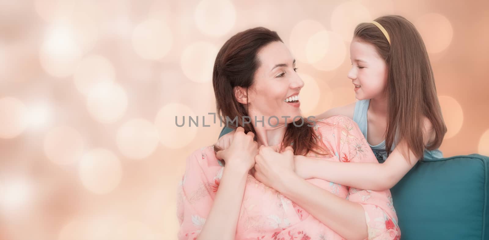 Glowing background against mother and daughter smiling at each other