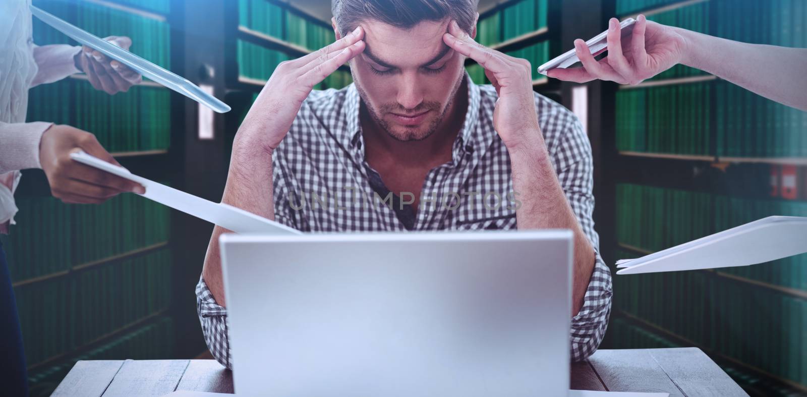 Businessman stressed out at work against close up of a bookshelf