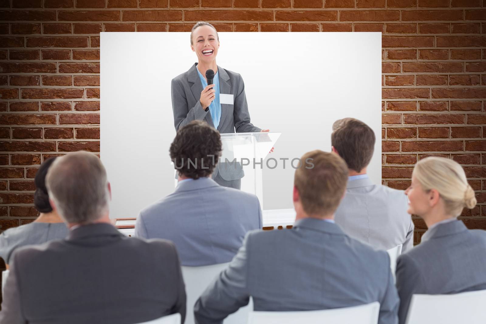 Businesswoman doing speech during meeting  against brick wall