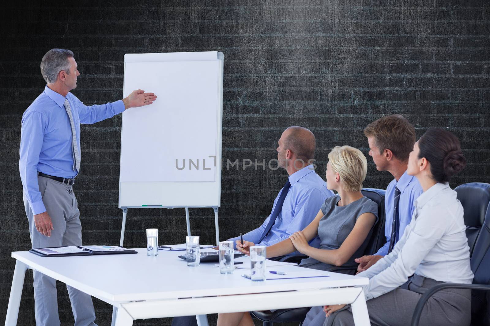 Business people listening during meeting  against a dark wall