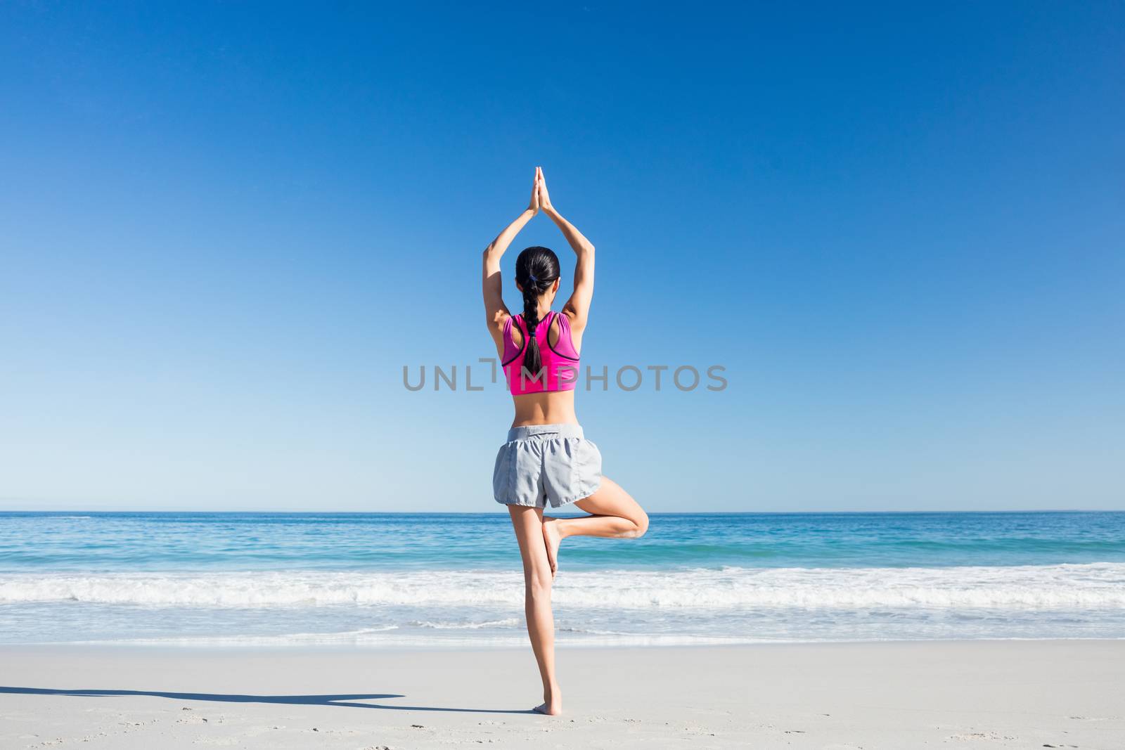 Woman doing yoga on the beach by Wavebreakmedia