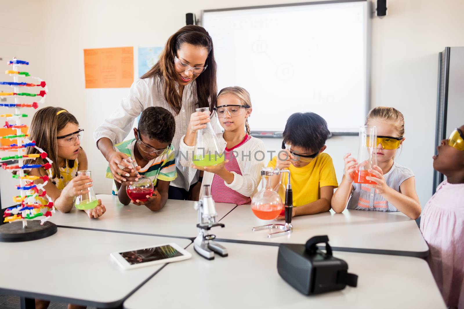 Pupils doing science with a teacher by Wavebreakmedia